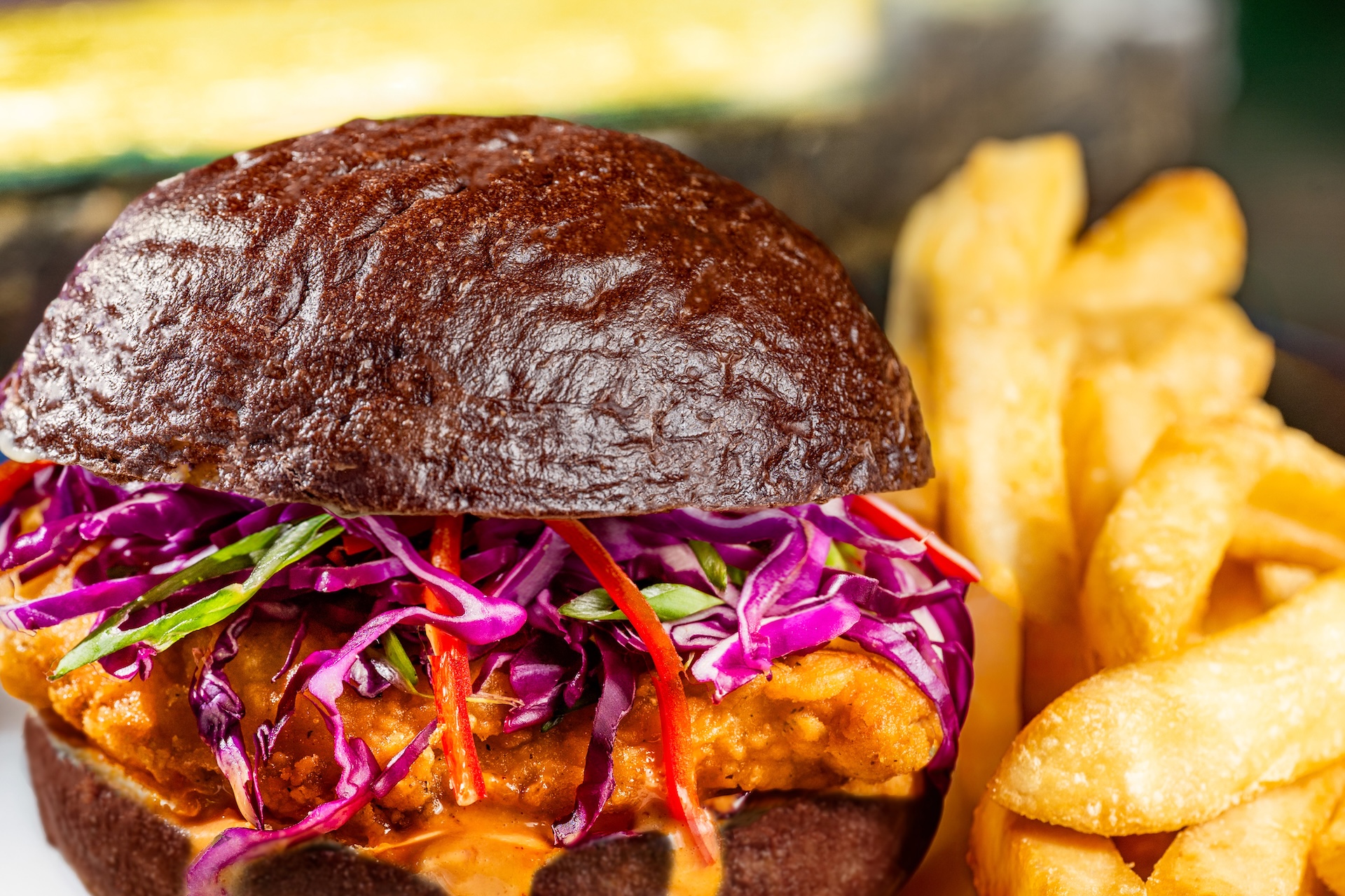 Devilish Crispy Chicken Sandwich: Ghoulish spiced mayonnaise, red cabbage, and Fresno peppers on a black kaiser roll served with french fries (New) (Available during regular park hours and Mickey’s Not-So-Scary Halloween Party; reservations recommended)