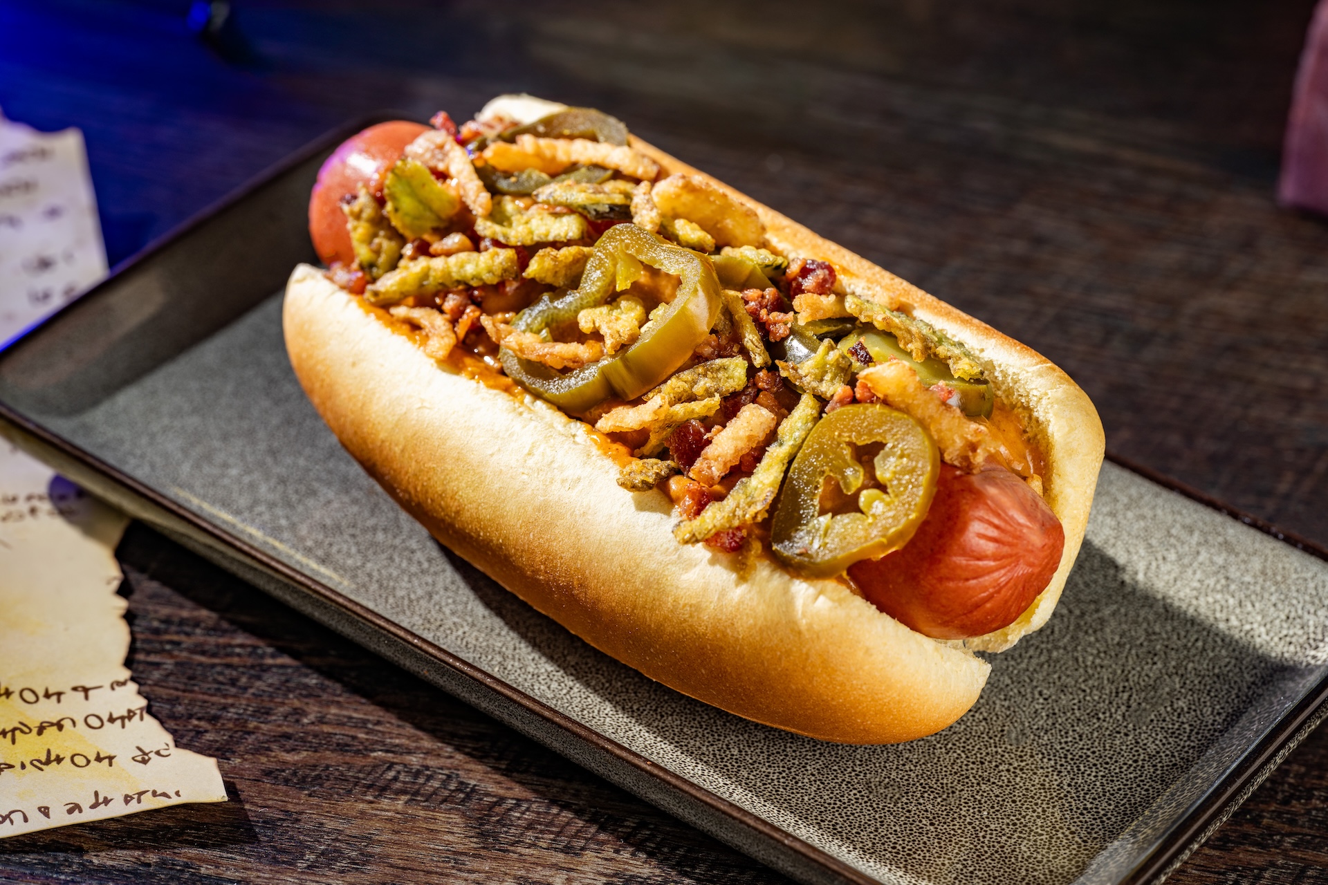 Jalapeño Popper Hot Dog topped with queso fundido, pickled and fried jalapeños, bacon, and onions (Available during Mickey’s Not-So-Scary Halloween Party only)