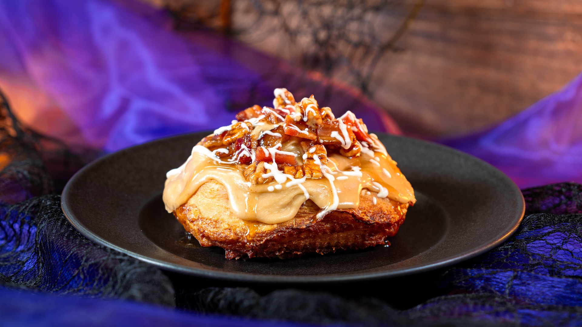 Maple-Bacon Cinnamon Roll: Cinnamon roll topped with maple cream cheese, glazed bacon, and pecans drizzled with white chocolate (Available Aug. 18 through Jan. 6, 2027)