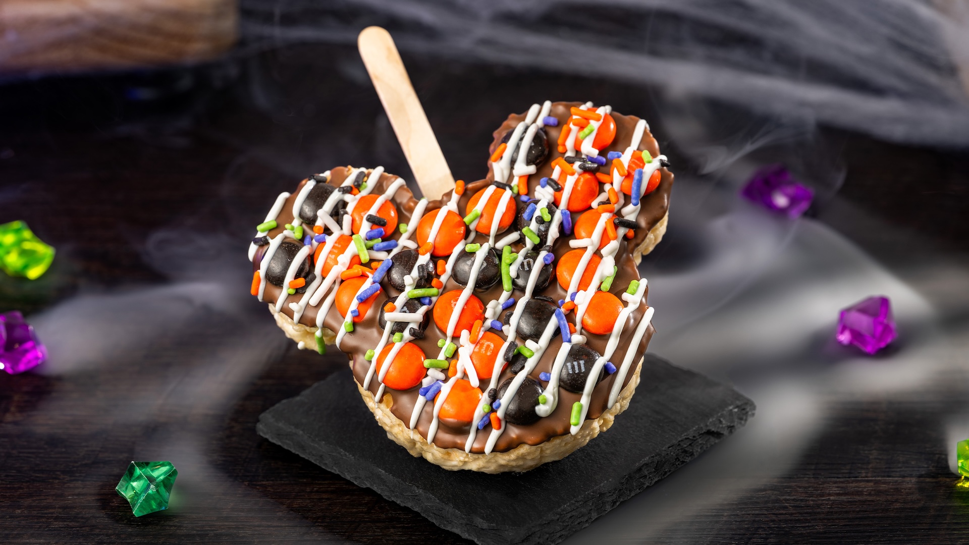 Mickey Halloween Cereal Treat with M&M’S Milk Chocolate Candies: Crisped rice cereal treat with milk chocolatey coating, M&M'S milk chocolate candies Halloween blend, Halloween sprinkles, and white chocolatey drizzle 