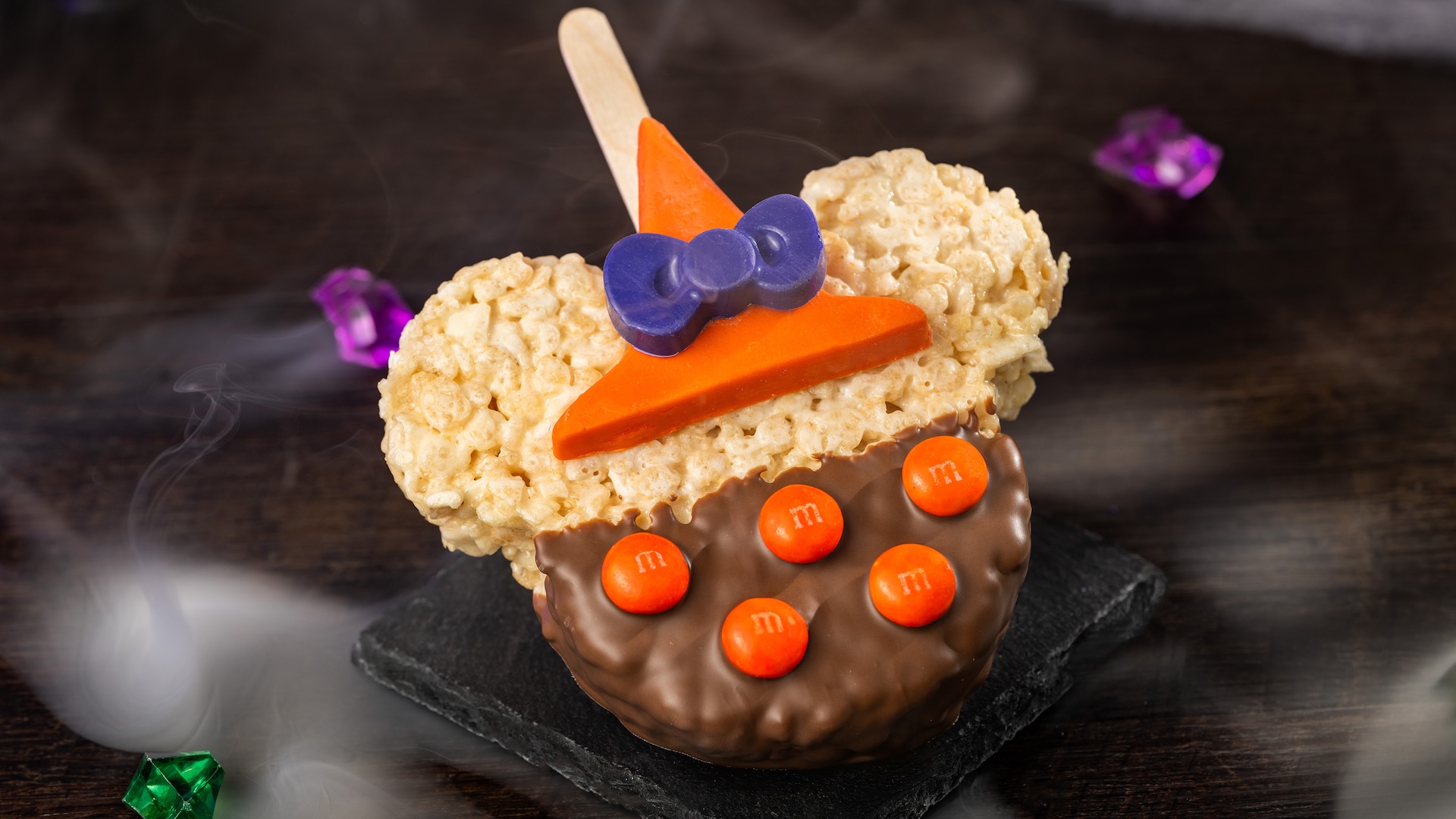 Minnie Witch Cereal Treat with M&M’S Milk Chocolate Candies: Crisped rice cereal treat with milk chocolatey coating, M&M'S milk chocolate candies, and chocolatey witch hat 