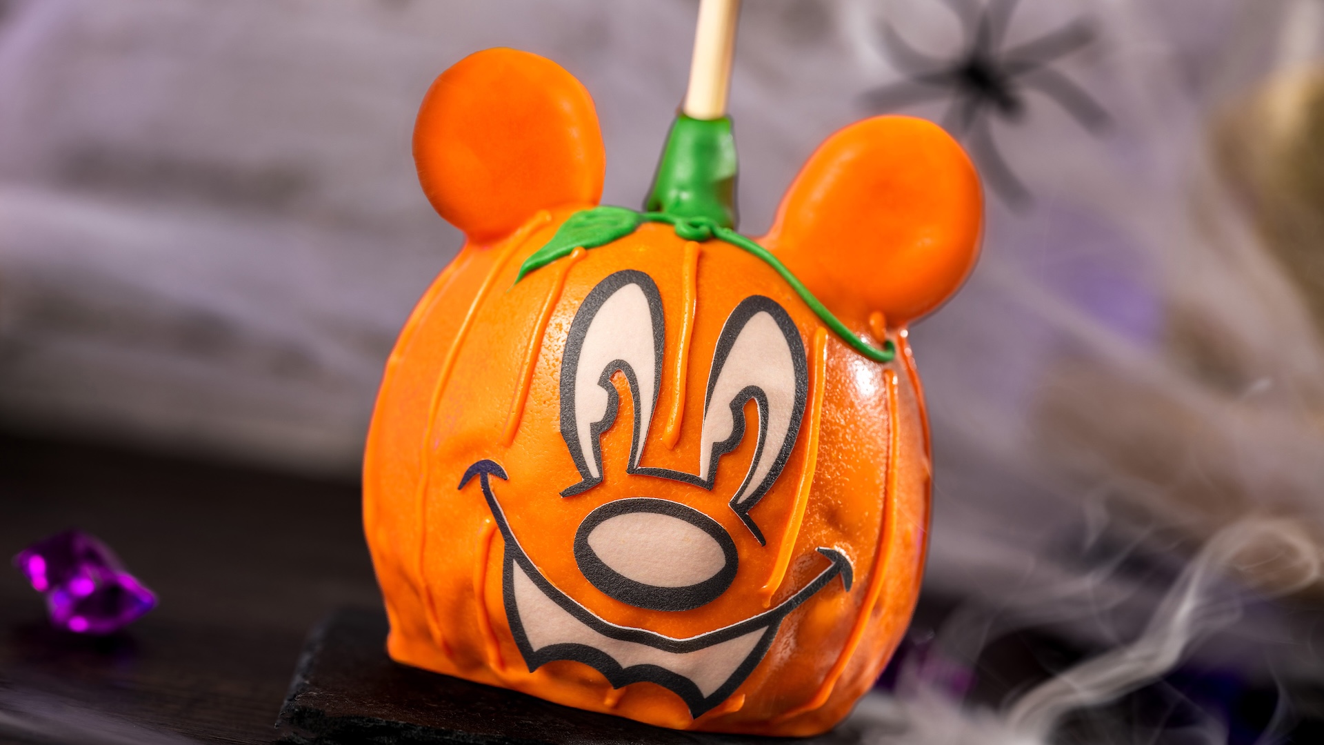Mickey Pumpkin Caramel Apple: Granny Smith apple with marshmallow ears dipped in Werther’s Original caramel and colored chocolatey coating with fondant features 