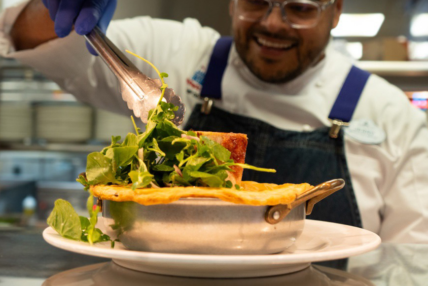 Chef Jerry placing garnish on dish.